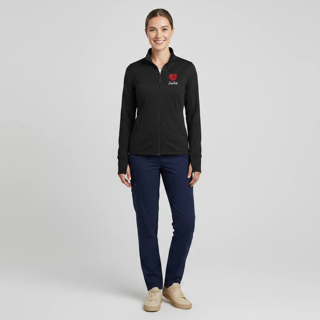Ashtown Clothing women's black performance full-zip medical jacket with custom embroidery, worn with navy scrub pants.