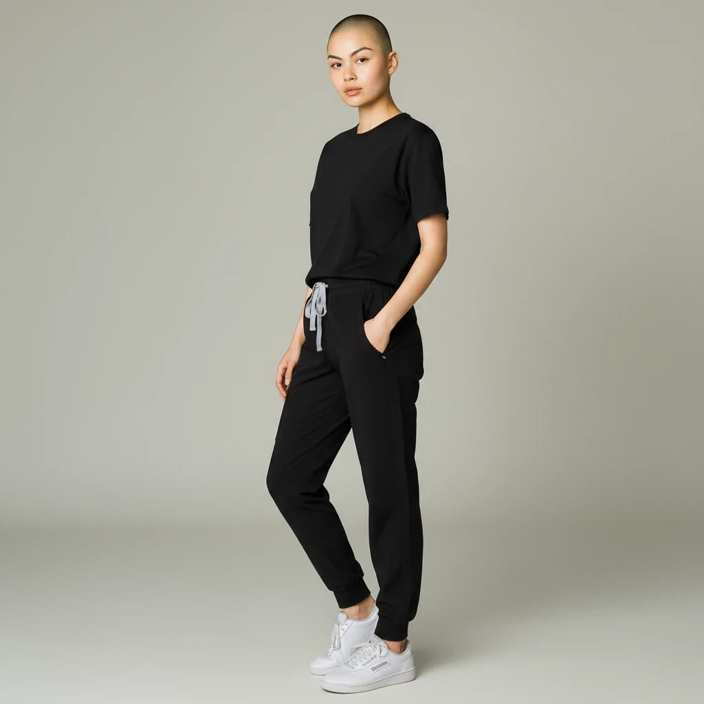 Ashtown Clothing women's black performance scrub joggers with ribbed cuffs and drawstring waist on a model.