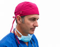 Ashtown Clothing fuchsia medical scrub hat worn by a male surgeon in blue scrubs against a white background
