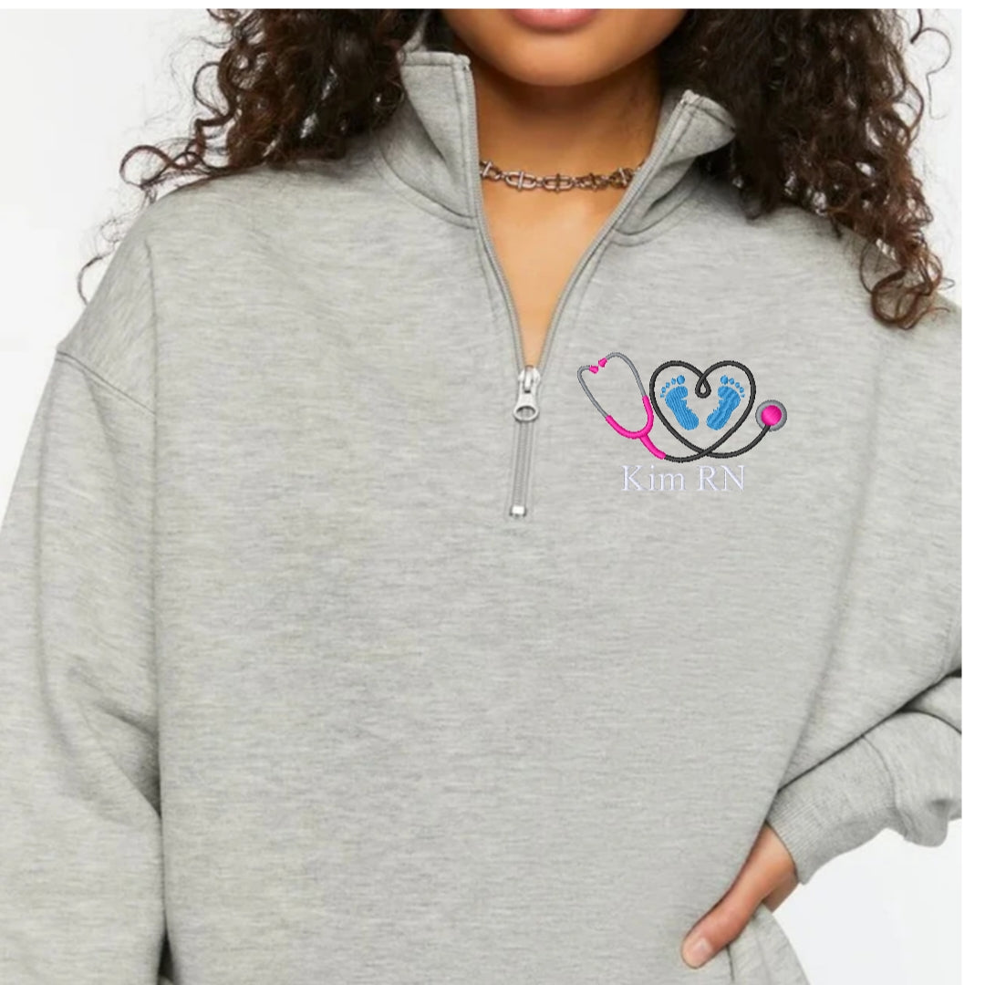 Ashtown Clothing grey fleece quarter-zip pullover with custom embroidered stethoscope and baby feet medical design