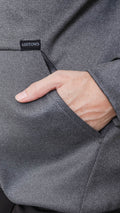 Close-up of a grey Ashtown Clothing performance hoodie showing a hand in the front pocket with a branded label.