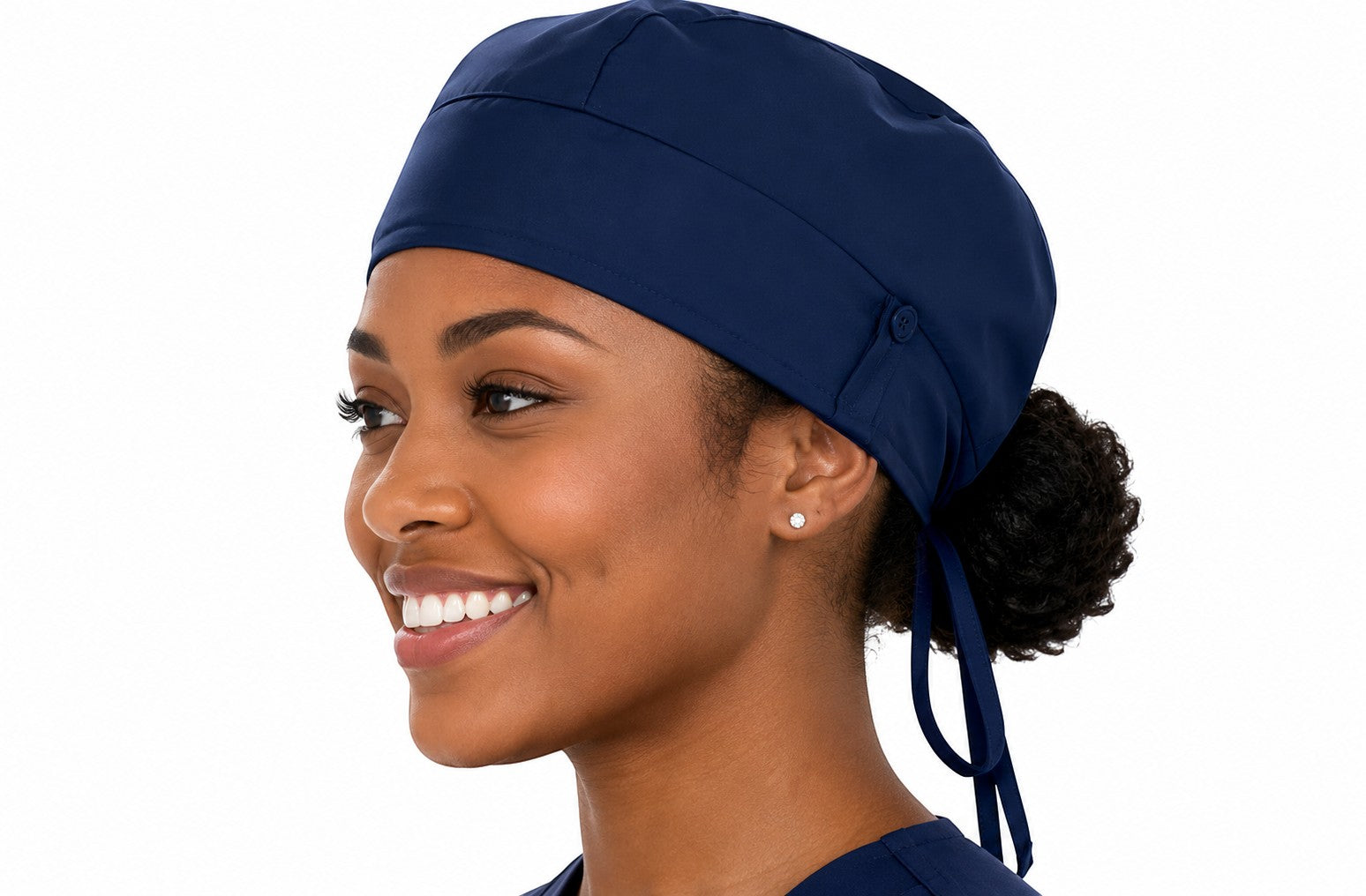 Ashtown Clothing navy blue medical scrub hat with adjustable tie-back closure worn by a smiling healthcare professional