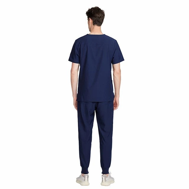 Back view of a man wearing an Ashtown Clothing navy blue jogger scrub set with ribbed ankle cuffs.